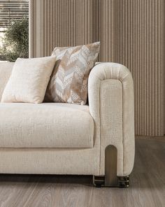 a white couch sitting in front of a window covered in pillows and throw pillow covers