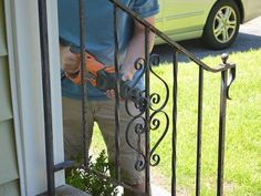 a man is using a power drill to trim the railing outside his house with an orange and black cordless tool