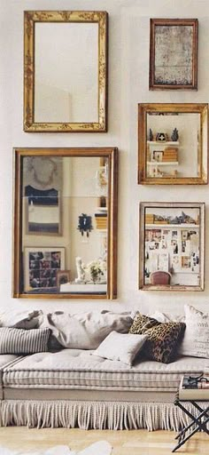 a living room filled with furniture and framed pictures on the wall above it's couch