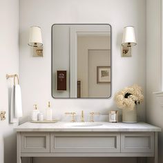 a white bathroom with two sinks and a large mirror above the sink is decorated with flowers