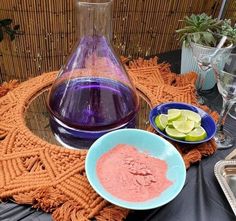 a table topped with plates and bowls filled with food next to a bottle of wine