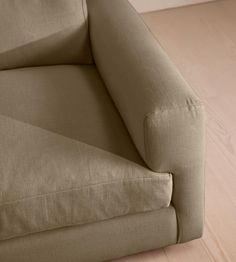 a close up view of the back end of a couch with wood floors and walls in the background