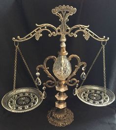 an ornate metal scale with two candles on each side and one candle holder in the middle