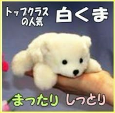 a small white teddy bear sitting on top of someone's hand in an advertisement