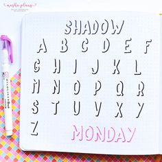 an open notebook with the words monday written in cursive writing on it next to a marker