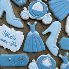 some cookies that are shaped like princess dresses and shoes with name tags on the top