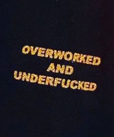 the words over worked and underfucked written in yellow on a black background