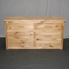 a wooden dresser sitting on top of a gray floor