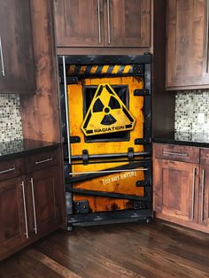 a caution sign is in the middle of a kitchen cabinet door that has been opened