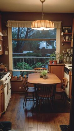 a kitchen with a table and chairs in front of a window that looks out onto the yard