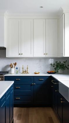 a kitchen with blue cabinets and white counter tops, gold pulls on the cabinet doors