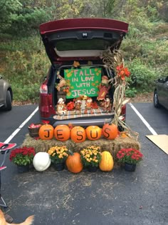 the trunk of a car is decorated with pumpkins, hay and other fall decorations