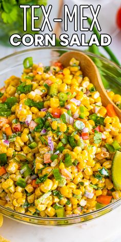 mexican corn salad in a glass bowl with a wooden spoon and lime wedges on the side