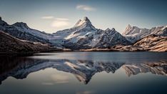 the mountains are reflected in the still water