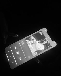 a cell phone is being held up in the dark