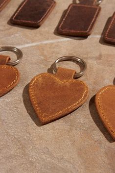 leather heart shaped keychains are lined up on a table