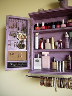 an open purple wooden box with jewelry and bracelets on it's sides, hanging from the wall