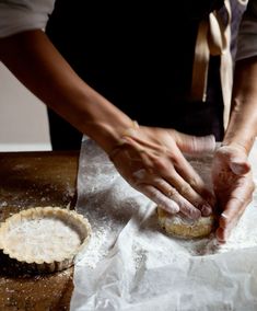 a person in an apron is kneading some food