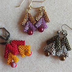 three pairs of beaded earrings sitting on top of a table