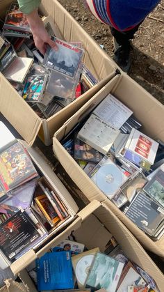 several boxes filled with books and dvds on top of the ground next to each other