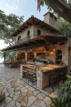 an outdoor kitchen with stone counters and seating