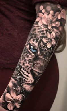 a woman's arm with a tiger and flowers on it