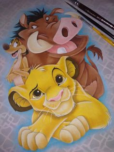 a drawing of the lion king and his cubs with colored pencils next to it