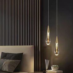 three light bulbs hanging over a bed in a room with black walls and wooden slats