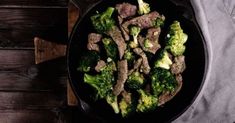 steak and broccoli in a skillet on a wooden table