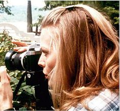 a woman holding a camera up to her face while another person holds it in front of her