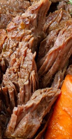 a close up of some meat and carrots on a plate