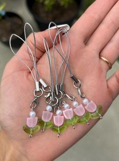 a person is holding several different colored glass items in their hand, including necklaces