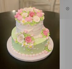 a three tiered cake decorated with flowers on a table