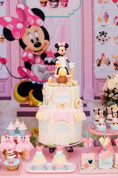 there is a birthday cake with minnie mouse on top and other cupcakes around it