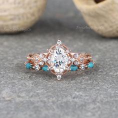 this is an image of a ring with turquoise stones and diamonds in the center on a stone surface