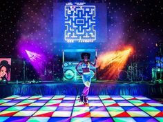 a woman standing on top of a colorful dance floor