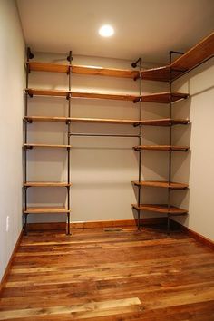 an empty walk in closet with shelves and wood flooring on the walls, along with hard wood floors