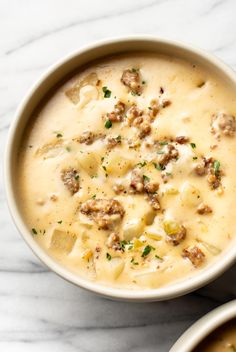 two bowls filled with soup on top of a white table