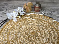 an embroidered doily with white flowers next to it