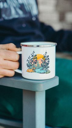 a person holding a coffee cup on top of a table