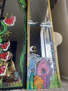 a young boy is looking at his reflection in a mirror with art work on it