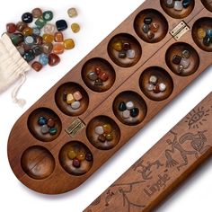 an assortment of rocks and stones in a wooden box next to a bag of beads