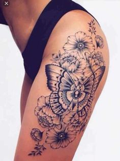 a woman's thigh with a butterfly and flowers tattoo on it