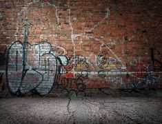 an old brick wall with graffiti on it