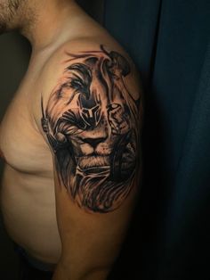 a man with a lion tattoo on his arm and chest is looking at the camera