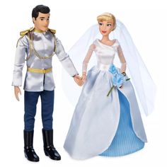 a bride and groom doll holding hands with each other on a white background in front of a white backdrop