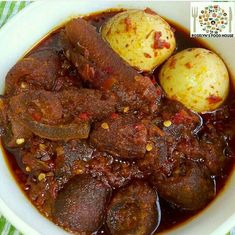 a white bowl filled with meat and potatoes