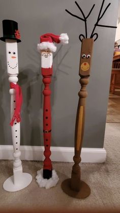 three wooden poles decorated to look like santa claus, snowman and rudolph the reindeer