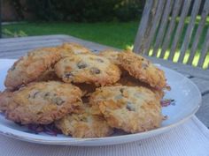 a white plate topped with cookies sitting on top of a wooden table next to a green field