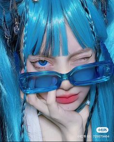 a woman with blue hair and glasses on her face